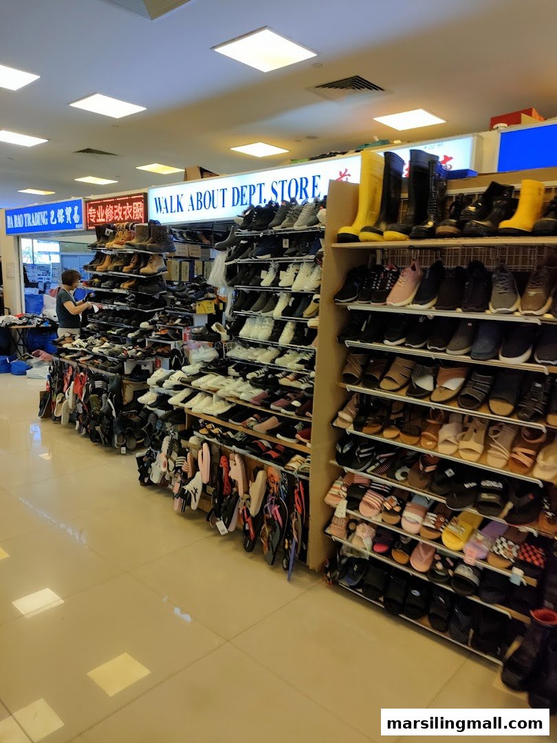 An interior view of Walk About Department Store, showcasing a wide variety of shoes on display shelves.