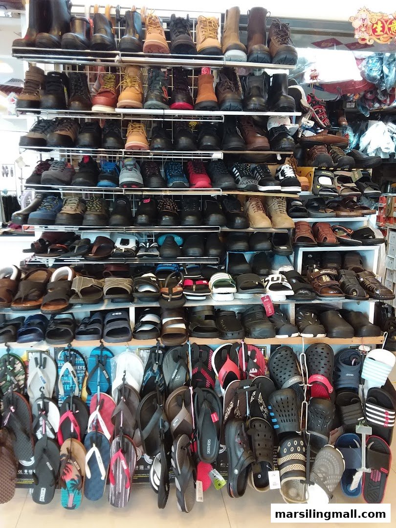 A wide variety of footwear, including boots, shoes, sandals, and flip-flops, displayed on multiple shelves.