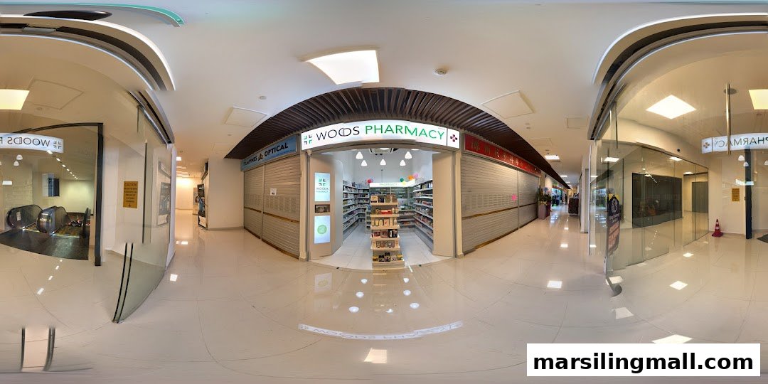 The brightly lit entrance of Woods Pharmacy, showcasing its well-stocked interior within a modern mall setting.