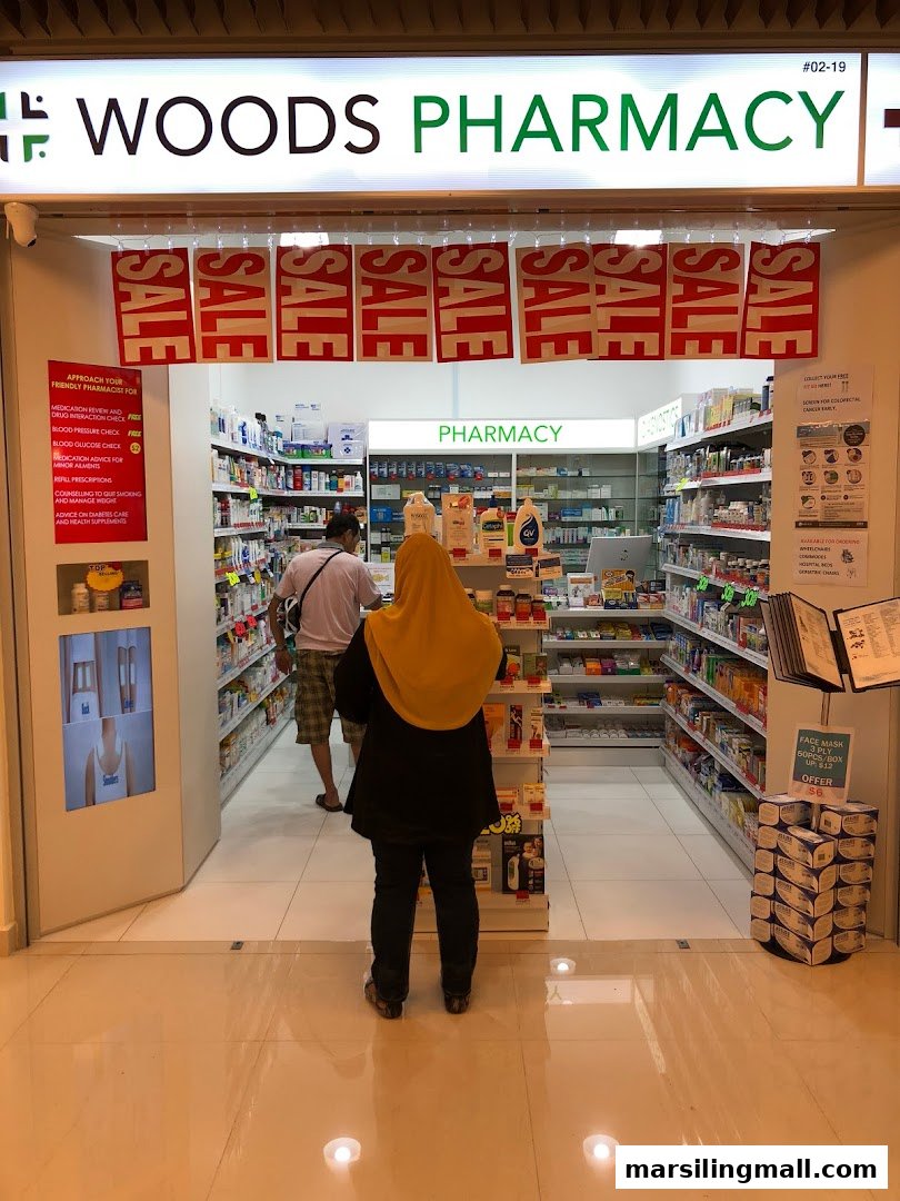 The brightly lit entrance of Woods Pharmacy, featuring a 'SALE' banner and visible interior shelves.