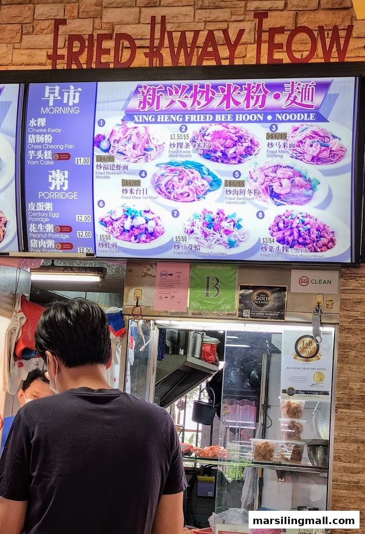 A customer views a digital menu board displaying various fried noodle and porridge dishes at Xing Heng Fried Bee Hoon . Noodle.