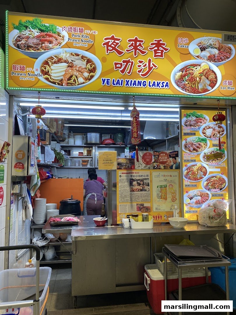 A bustling hawker stall, Ye Lai Xiang Laksa, showcasing its menu and kitchen operations.