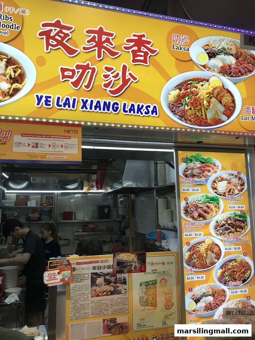 A vibrant hawker stall, Ye Lai Xiang Laksa, showcasing its menu and busy kitchen operations.