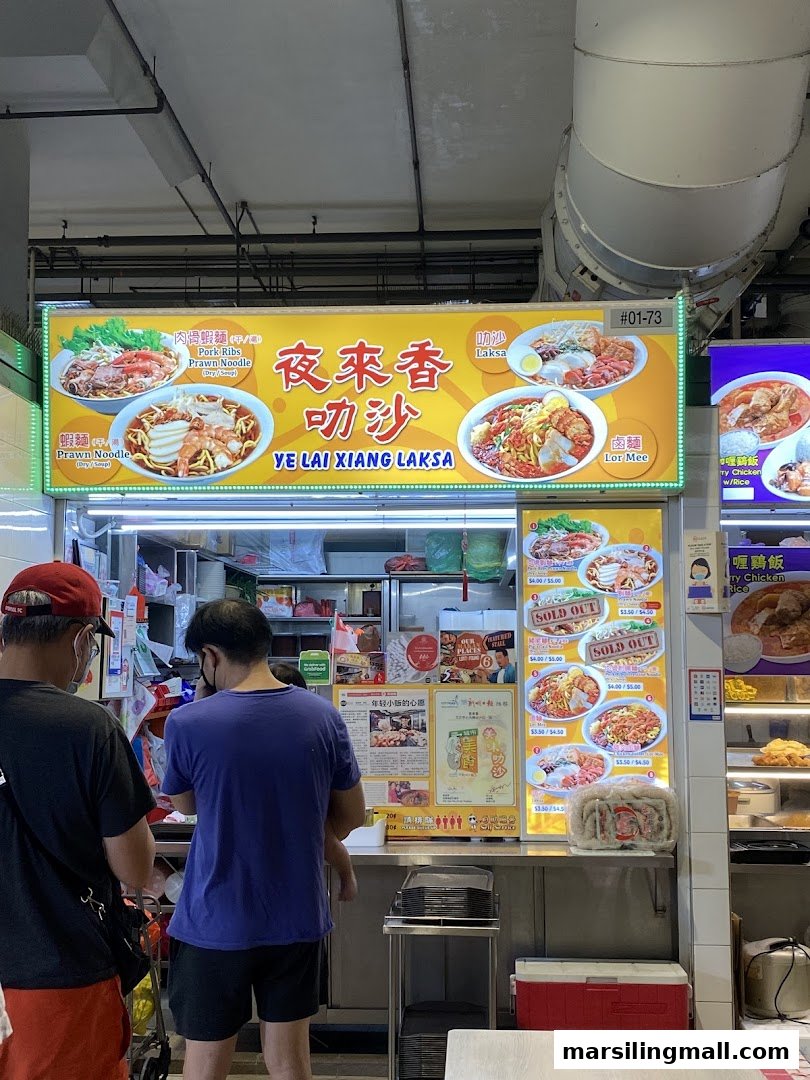 The vibrant front of Ye Lai Xiang Laksa food stall, showcasing its menu and customers.