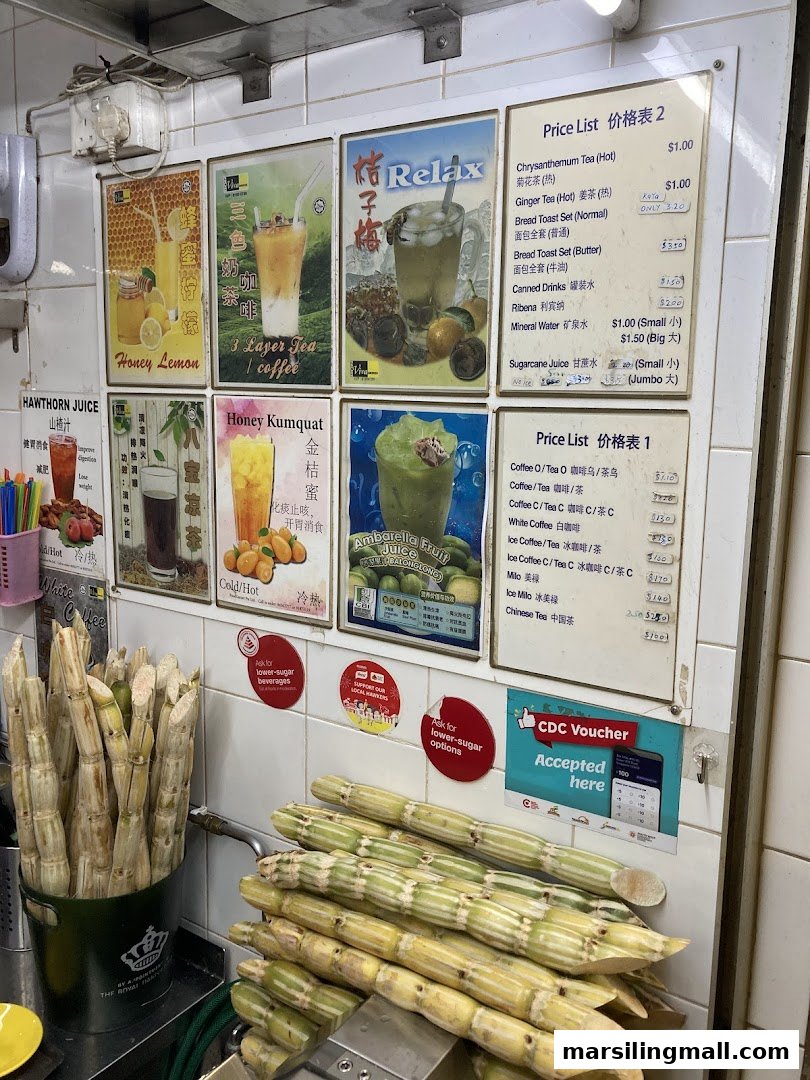 A vibrant beverage stall counter showcasing fresh sugarcane, various drink menus, and promotional signs.