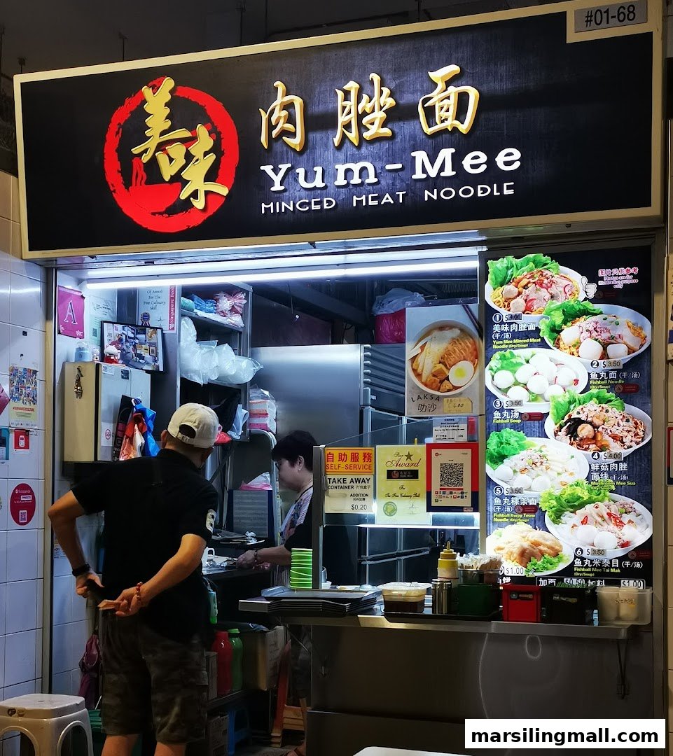 The vibrant storefront of Yum-Mee Minced Meat Noodle, showcasing its sign and menu displays.