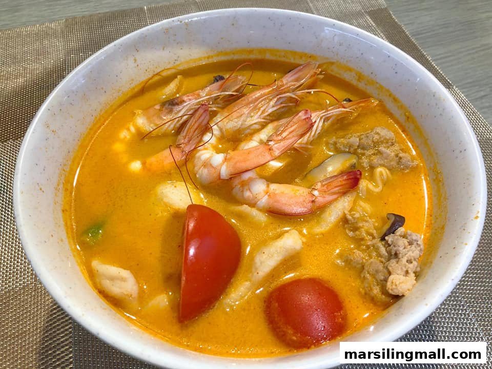 A vibrant bowl of seafood soup with shrimp, tomatoes, and other ingredients in a rich broth.