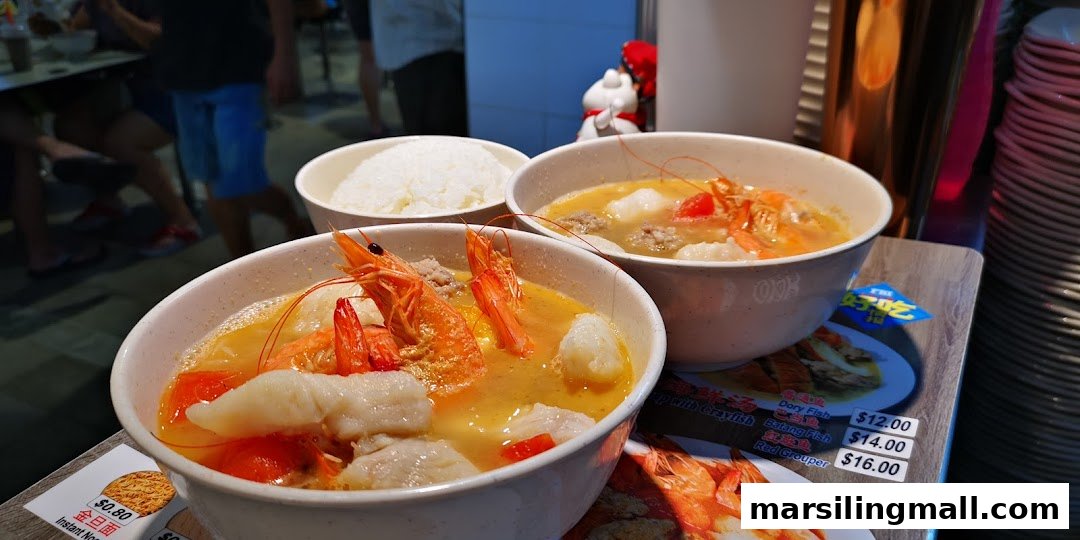 Two bowls of vibrant seafood soup with prawns and fish, served with a side of rice.