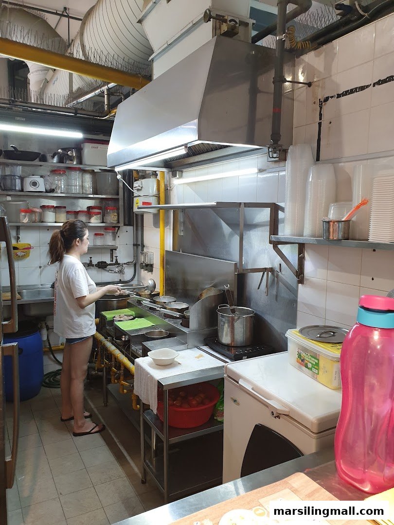 A chef prepares dishes in the bustling kitchen of YumSea Seafood Soup.