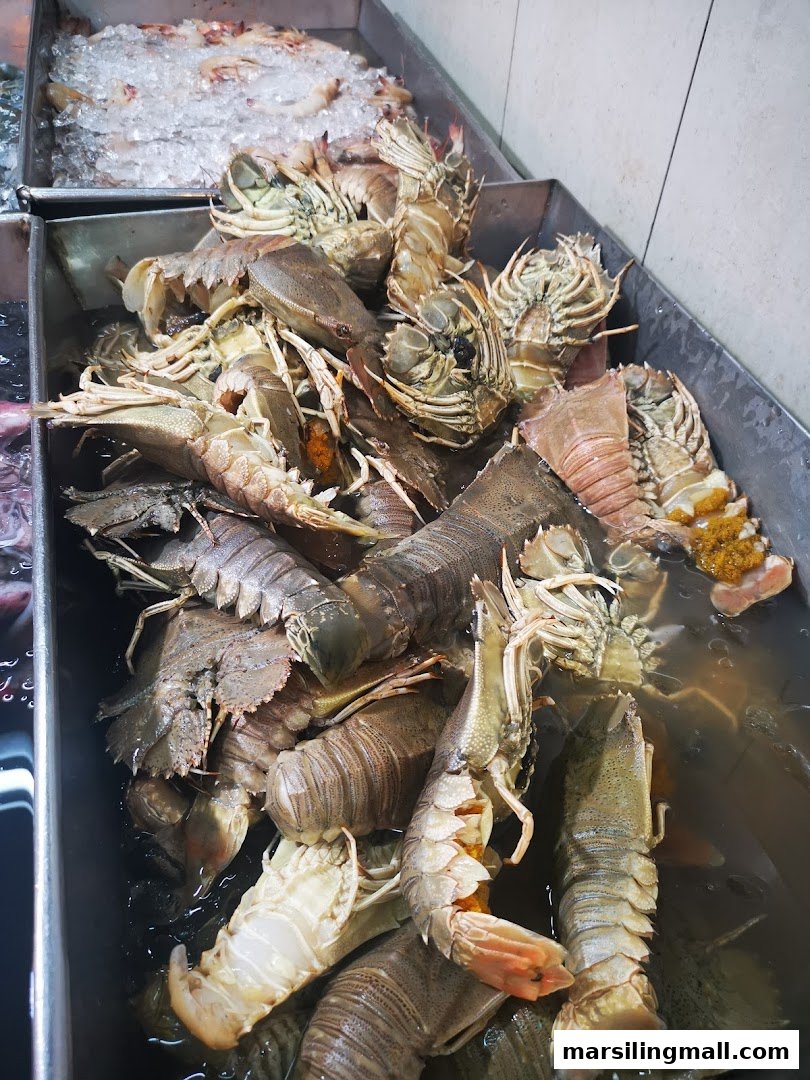 A display of fresh mantis shrimp and prawns in a seafood market.