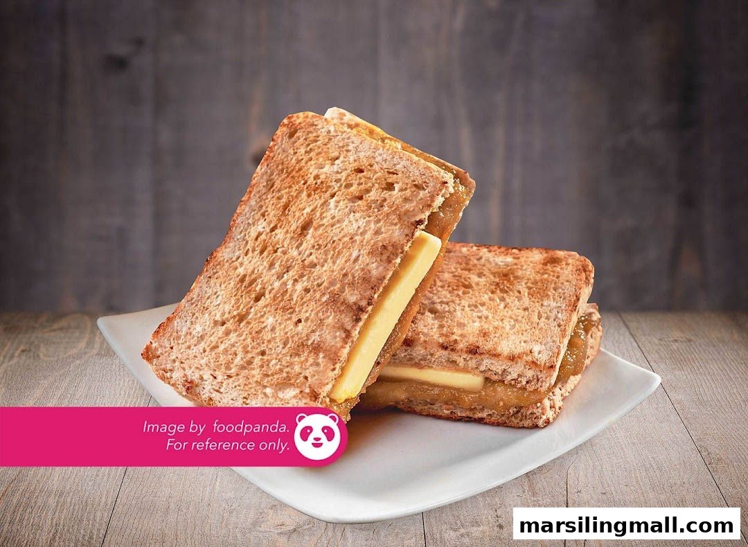 Two slices of traditional kaya toast with butter on a white plate, against a wooden background.