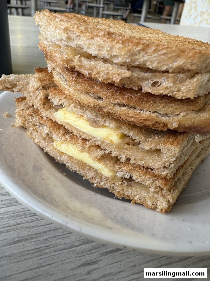 A close-up of traditional kaya toast with butter, served on a white plate.