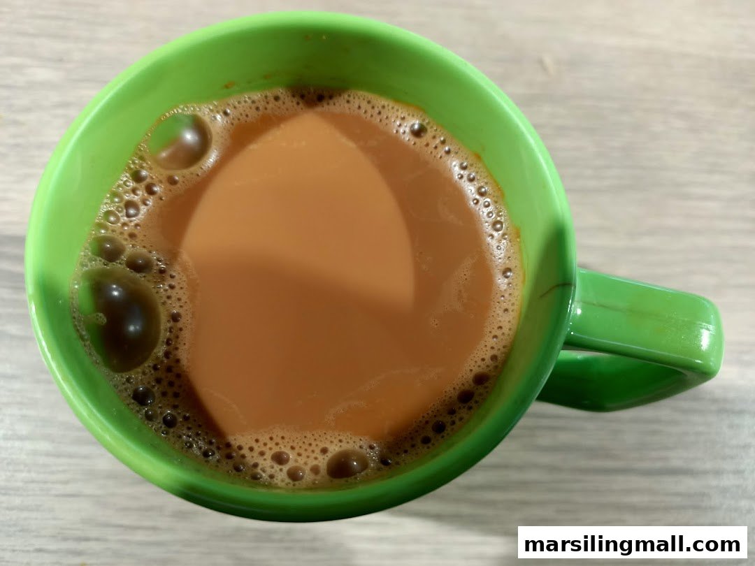 A vibrant green mug filled with a frothy, milky beverage, viewed from above.
