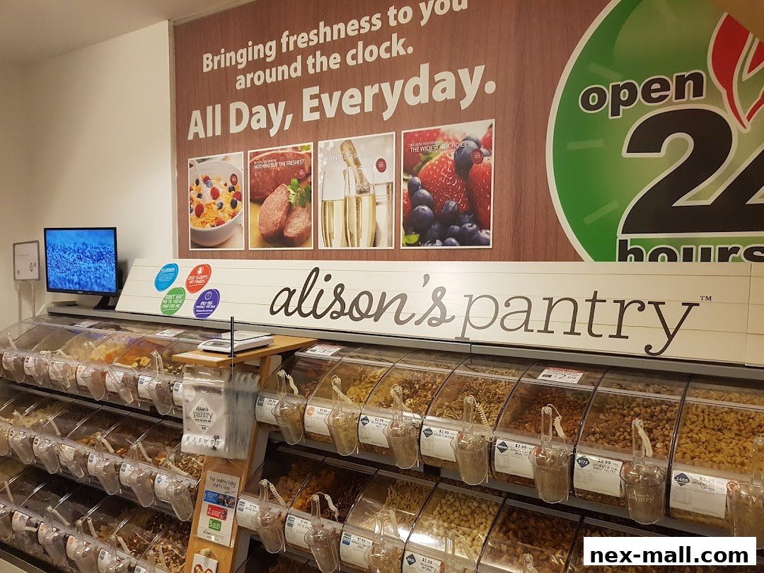 A grocery store aisle with bulk bins of nuts and dried fruits, and a sign for 'alison's pantry'.
