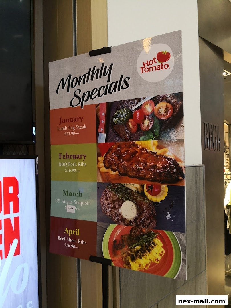 A sign displays monthly specials for Hot Tomato, featuring various meat dishes and prices.