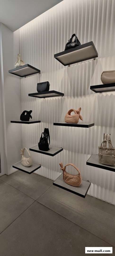 A stylish display of various handbags on illuminated shelves in a retail store.