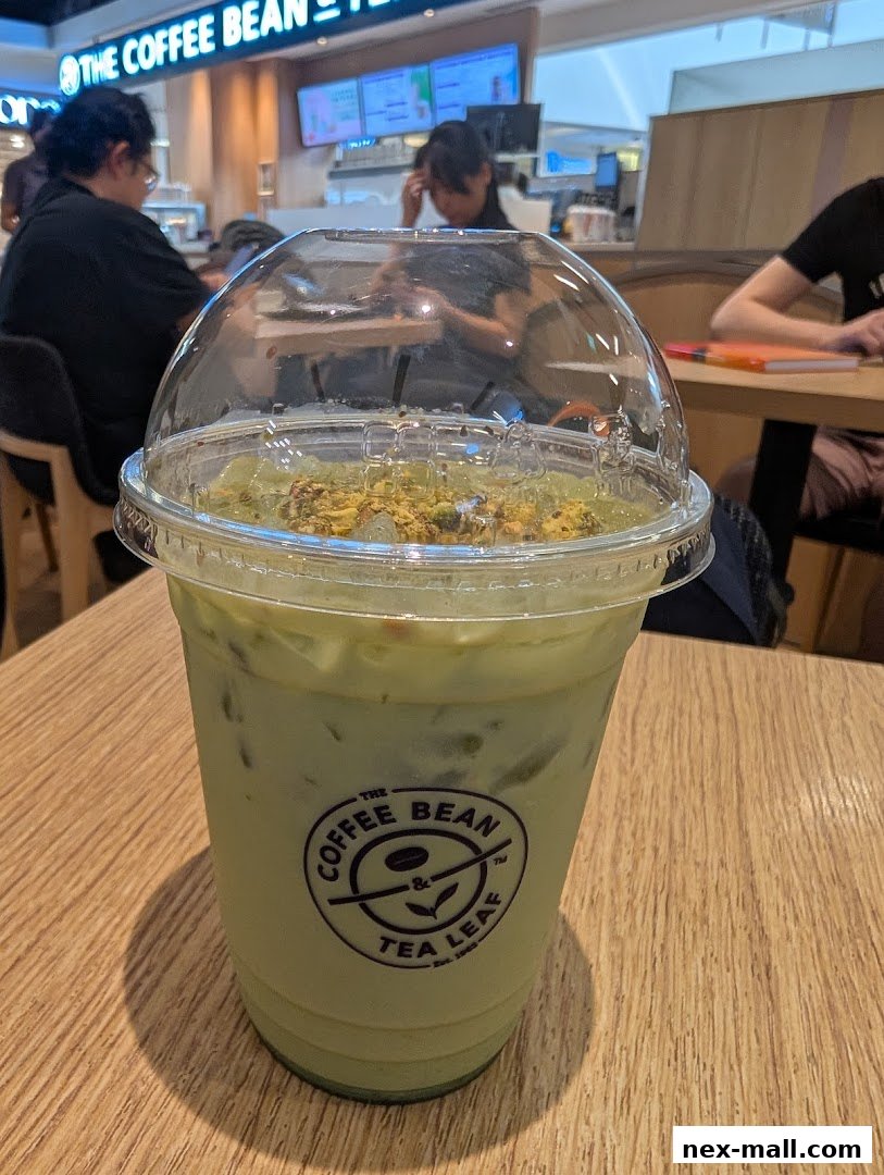 A close-up of a matcha latte with a domed lid and toppings at The Coffee Bean & Tea Leaf.