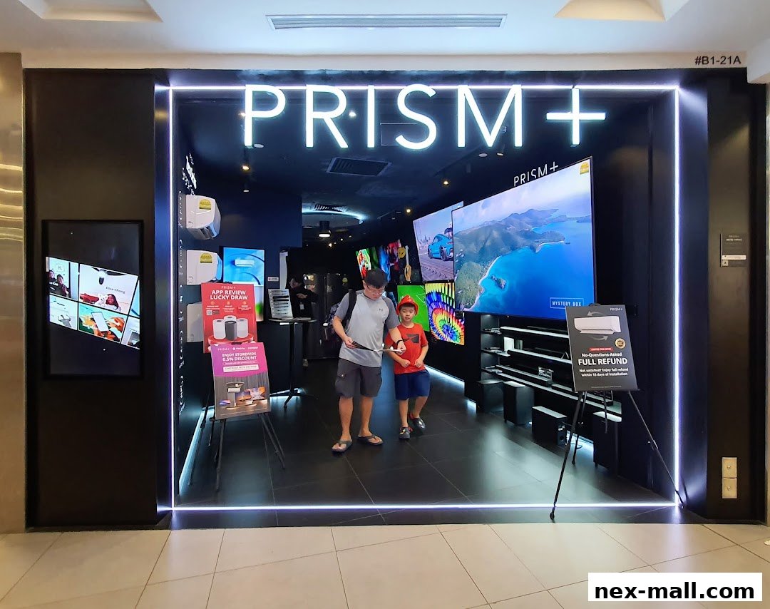 The entrance of PRISM+ electronics store with large TVs and promotional displays.