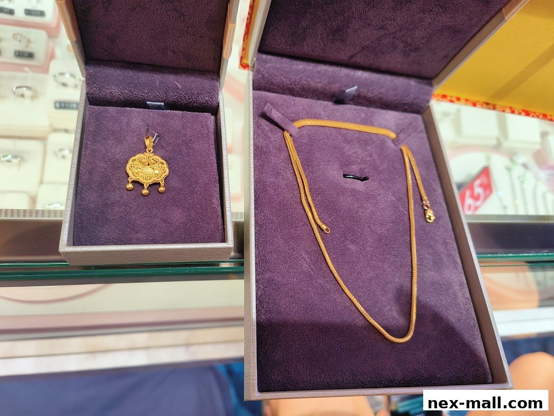 Two jewelry boxes display a gold pendant and a gold chain.
