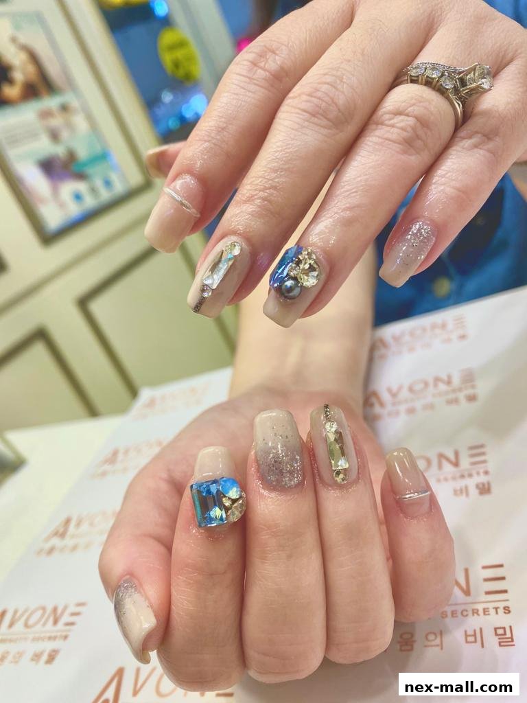 Close-up of hands with elaborately decorated nails featuring gems and glitter.