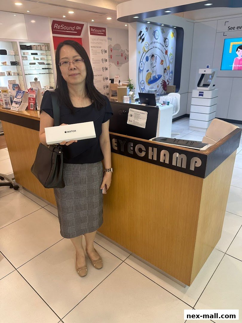 A woman holds an Apple Watch box inside an optical shop with displays of hearing instruments.