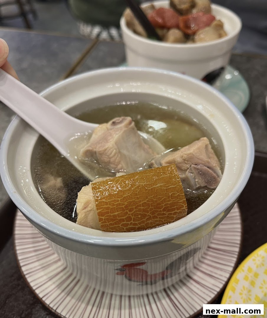 A close-up shot of a bowl of nourishing soup with tender meat and a unique ingredient.