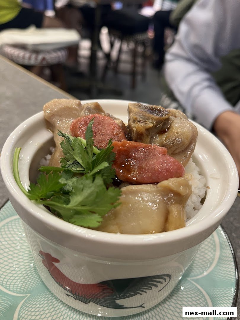 A close-up of a delicious rice dish with meat and sausage, garnished with cilantro.