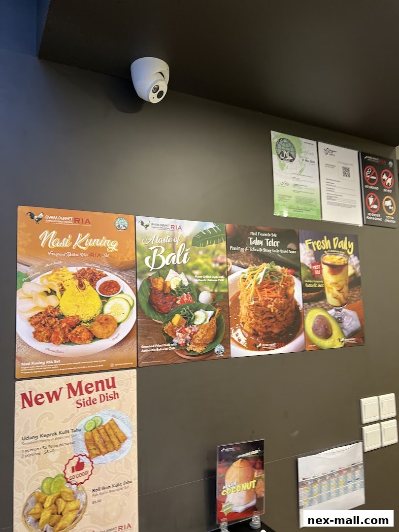 A wall display featuring various Indonesian dishes and menu items from Ayam Penyet Ria.