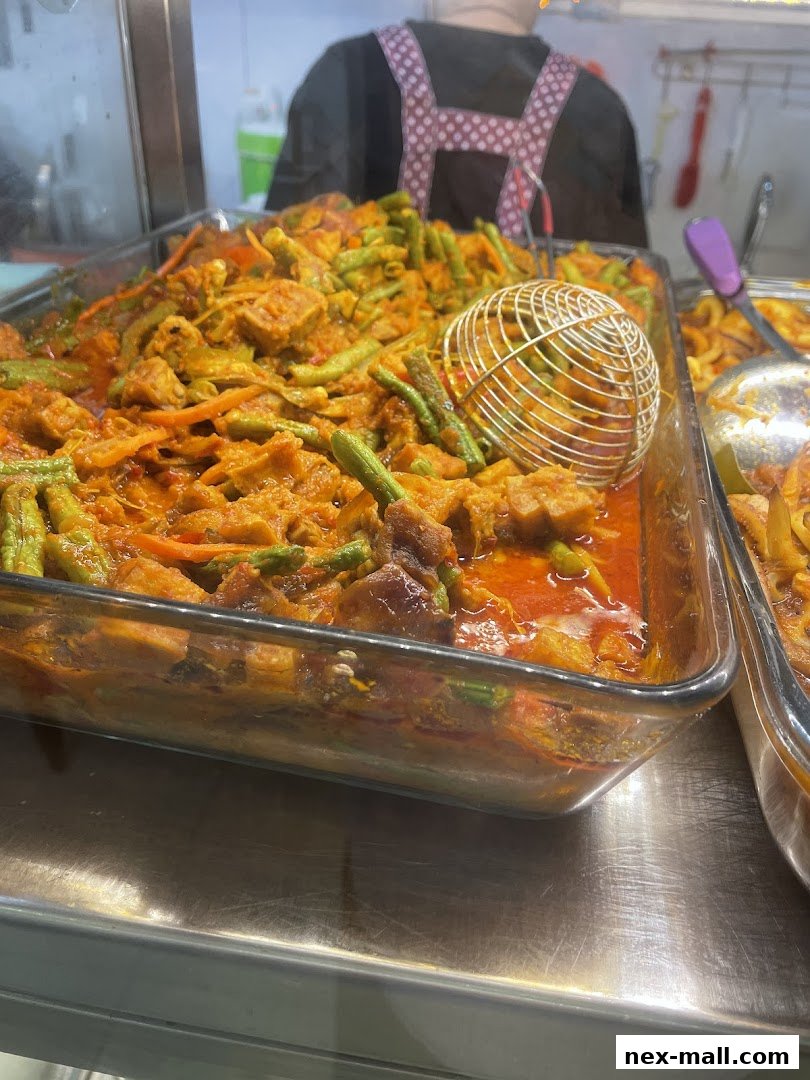 A close-up of a glass dish filled with a savory stew featuring meat and green beans.