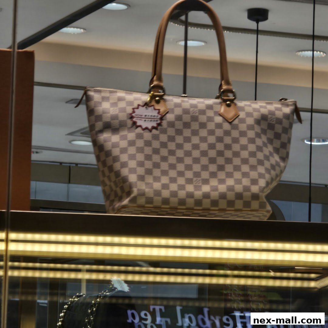 A checkered designer handbag displayed in a shop window with a price tag.