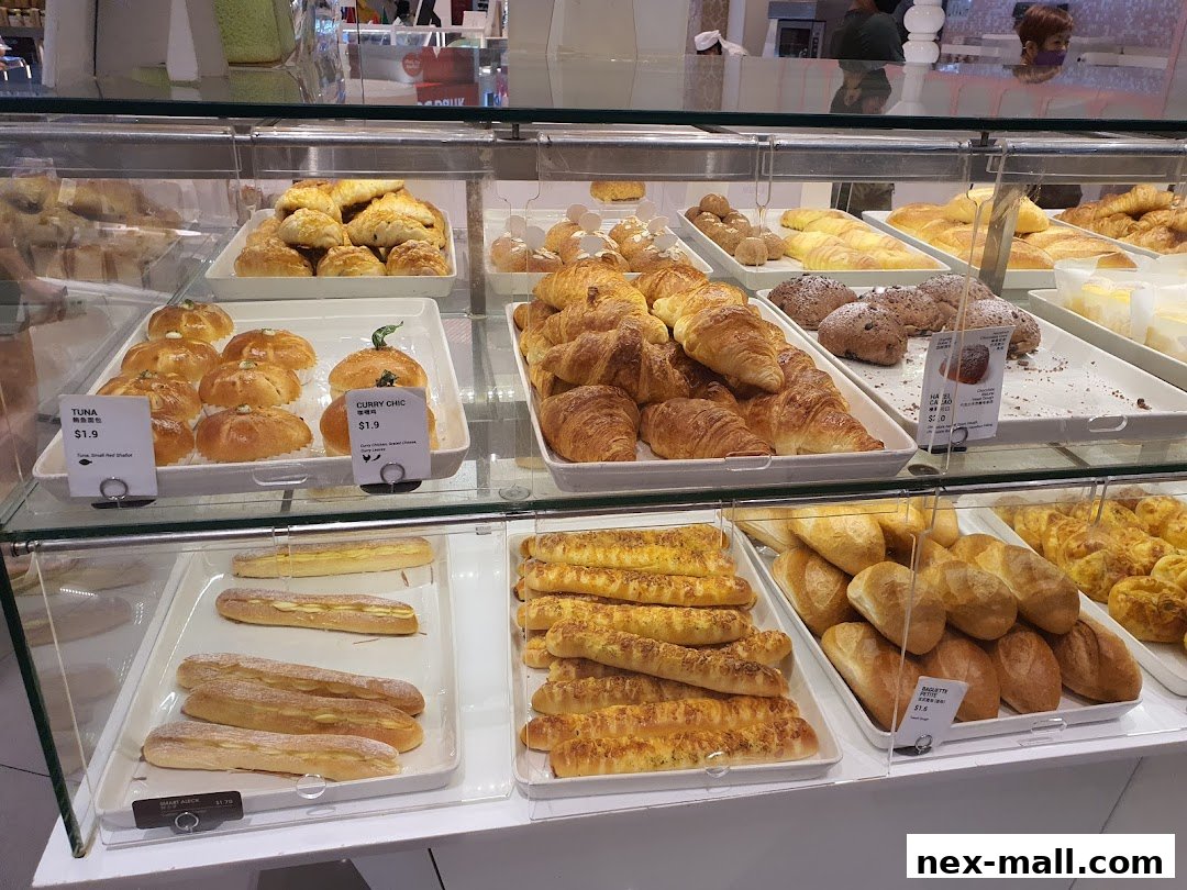 A display case filled with a variety of freshly baked breads and pastries.