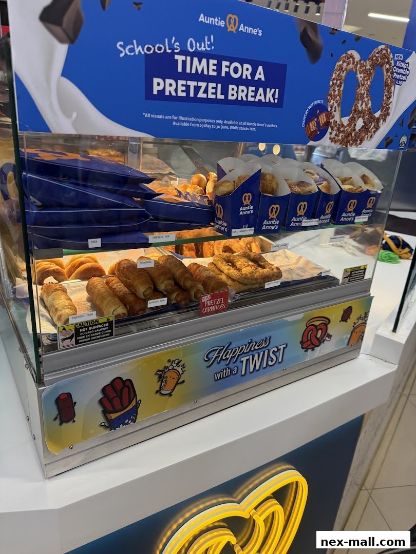 A display case filled with various Auntie Anne's pretzels and pretzel dogs.