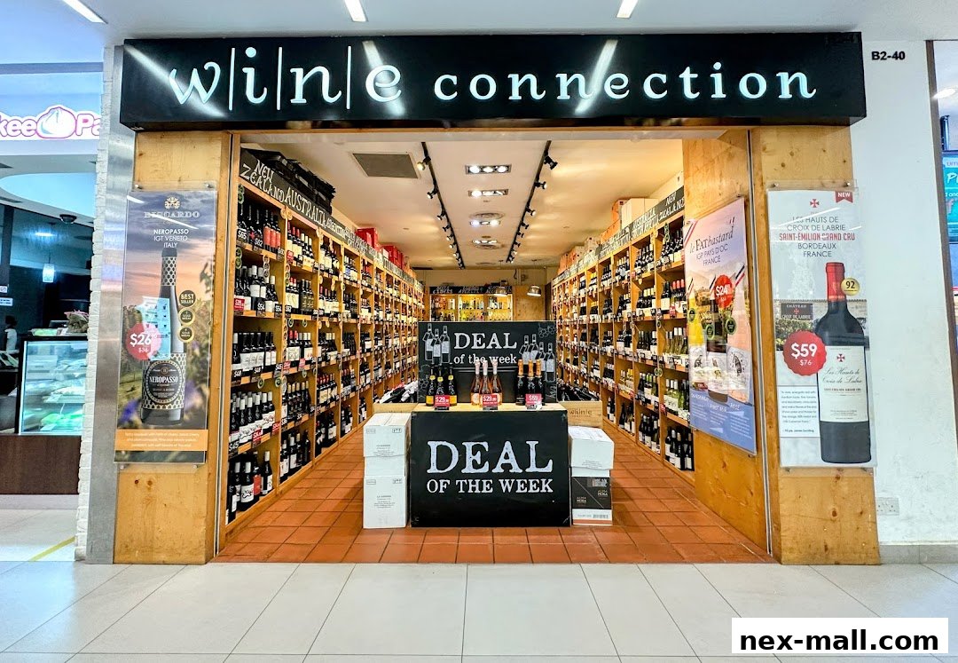 The entrance of Wine Connection NEX, showcasing shelves stocked with various bottles of wine and promotional displays.