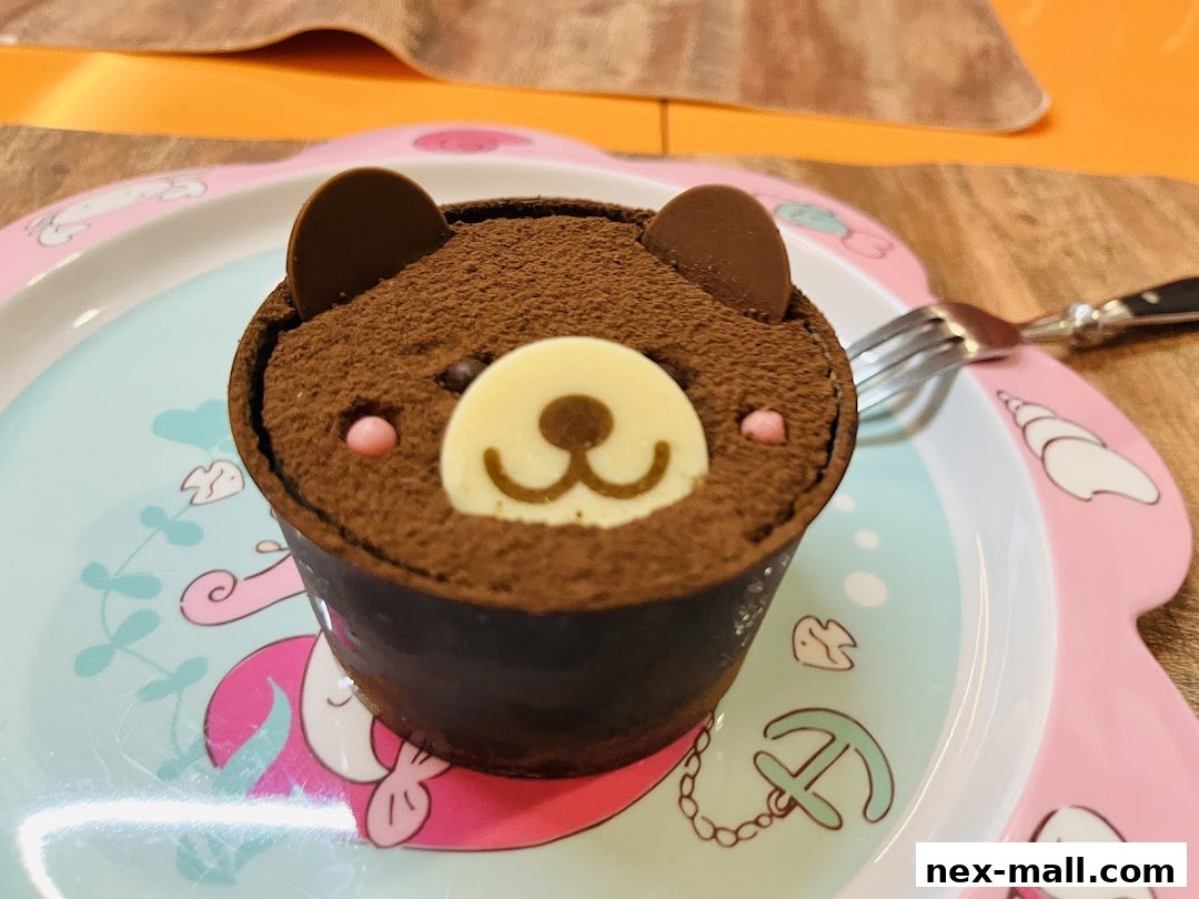 A close-up of a chocolate cake decorated to look like a bear's face on a whimsical plate.