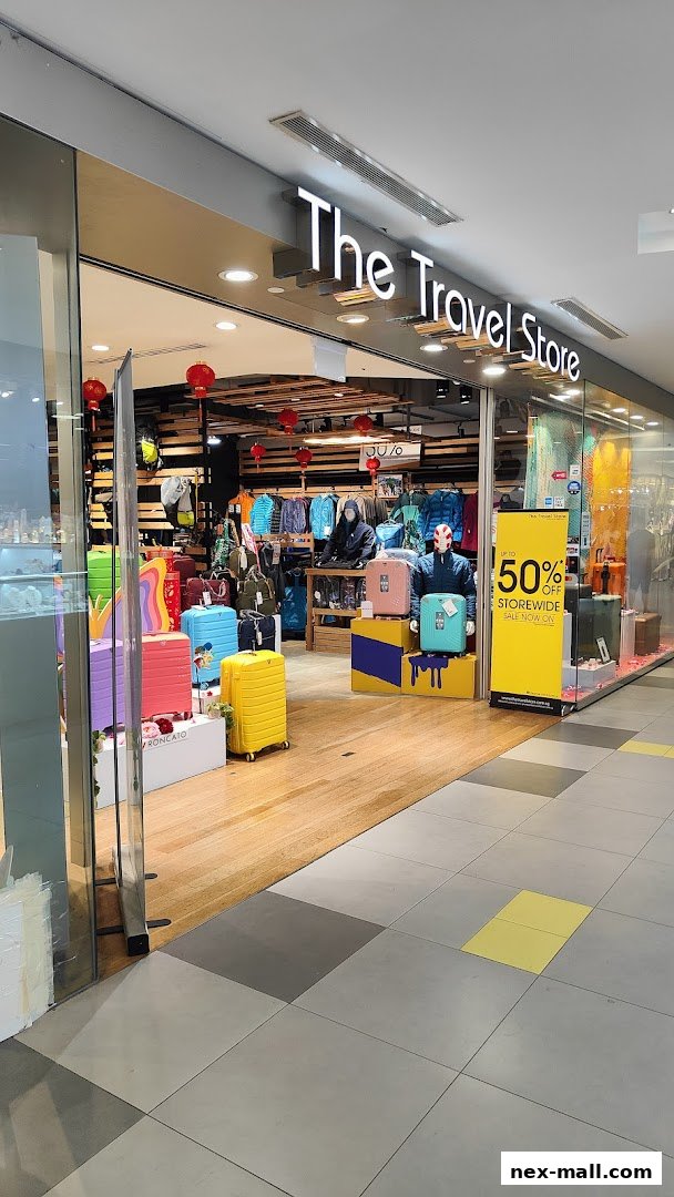The entrance of 'The Travel Store' showcasing colorful luggage and travel apparel.