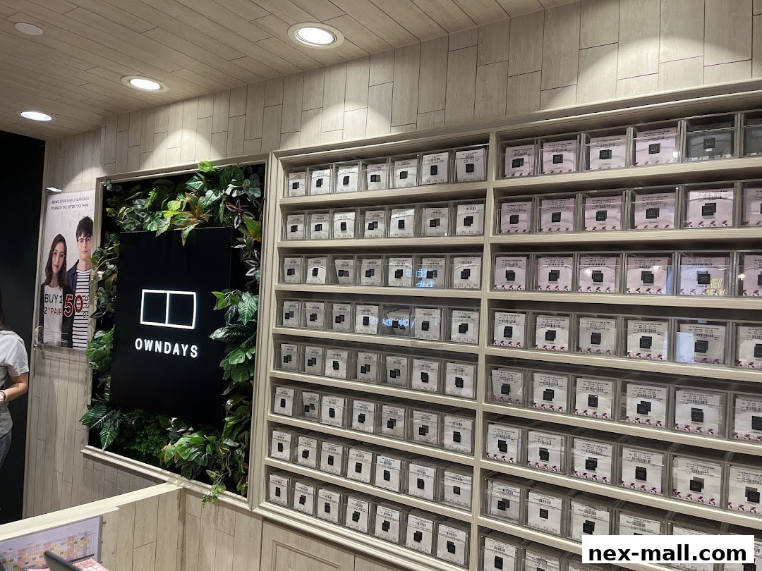 Interior view of OWNDAYS nex, showcasing a wall of eyewear cases and a promotional poster.
