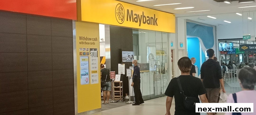The Maybank bank branch entrance with a yellow sign and people queuing.