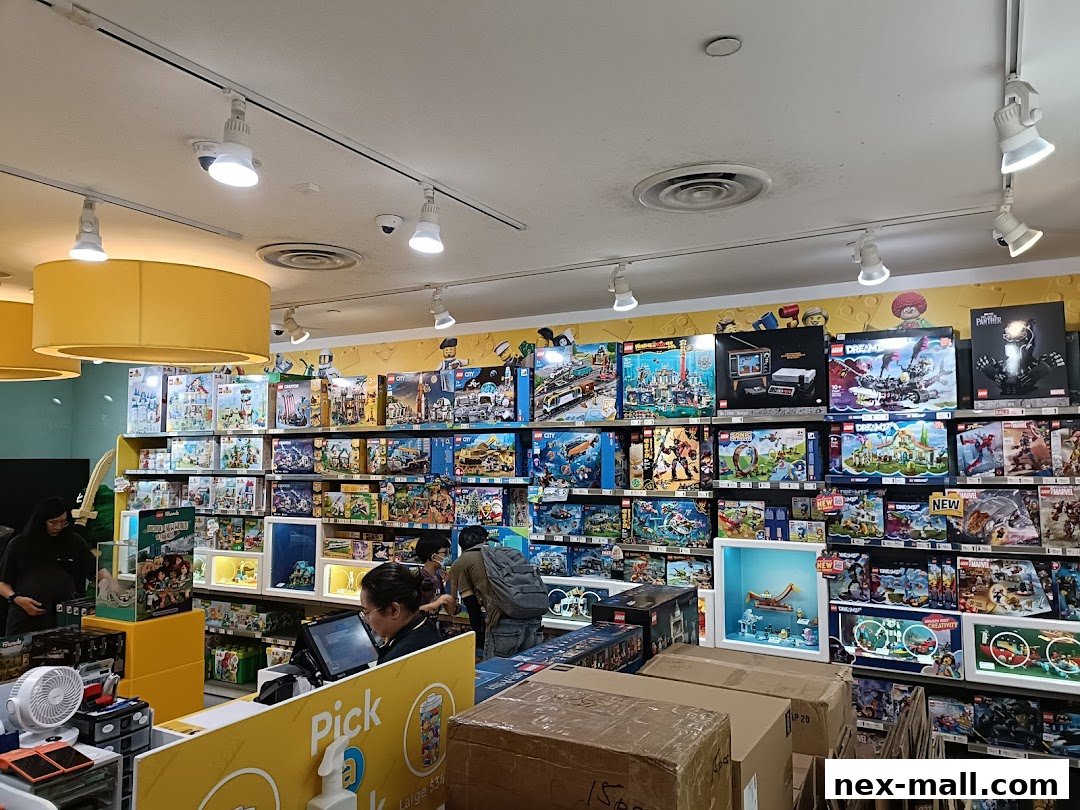 Interior of a LEGO store with shelves full of LEGO sets and customers browsing.