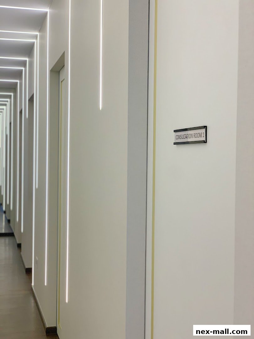 A modern hallway with illuminated vertical lines and a sign for Consultation Room 1.