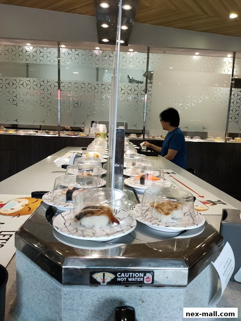 A conveyor belt sushi restaurant with various sushi dishes on plates.