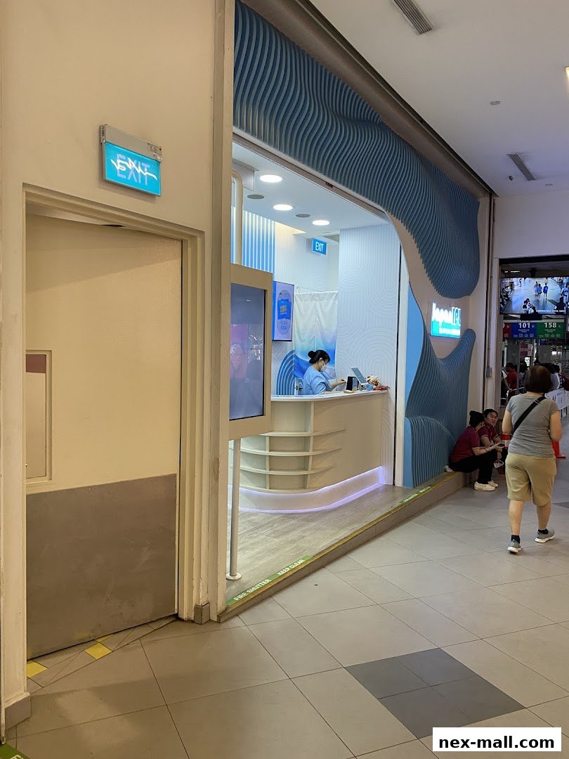 The entrance to Japan IPL Express NEX, a modern beauty salon with blue wave-like decor.