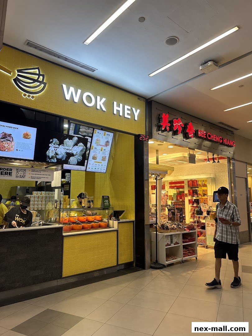 The Wok Hey shop front with bright yellow walls and a prominent sign, next to Bee Cheng Hiang.