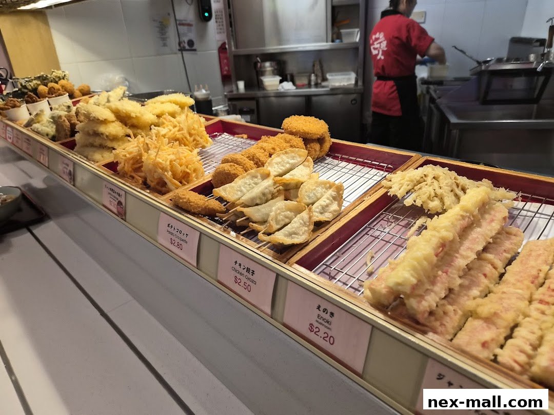 A display of various fried Japanese dishes, including gyoza, croquettes, and tempura.