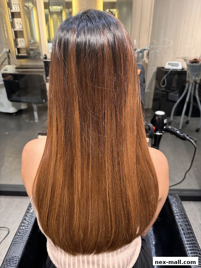 A person's back with long, straight, brown hair with subtle highlights.