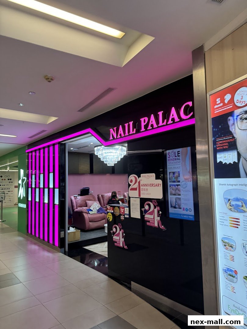 The entrance of Nail Palace, a nail salon with bright pink lighting and a chandelier.