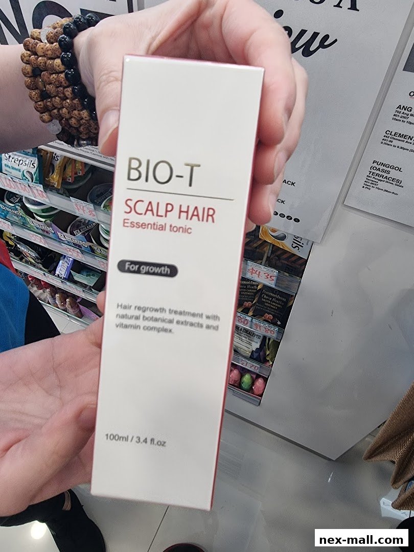A person holds a box of BIO-T SCALP HAIR Essential tonic for hair growth.