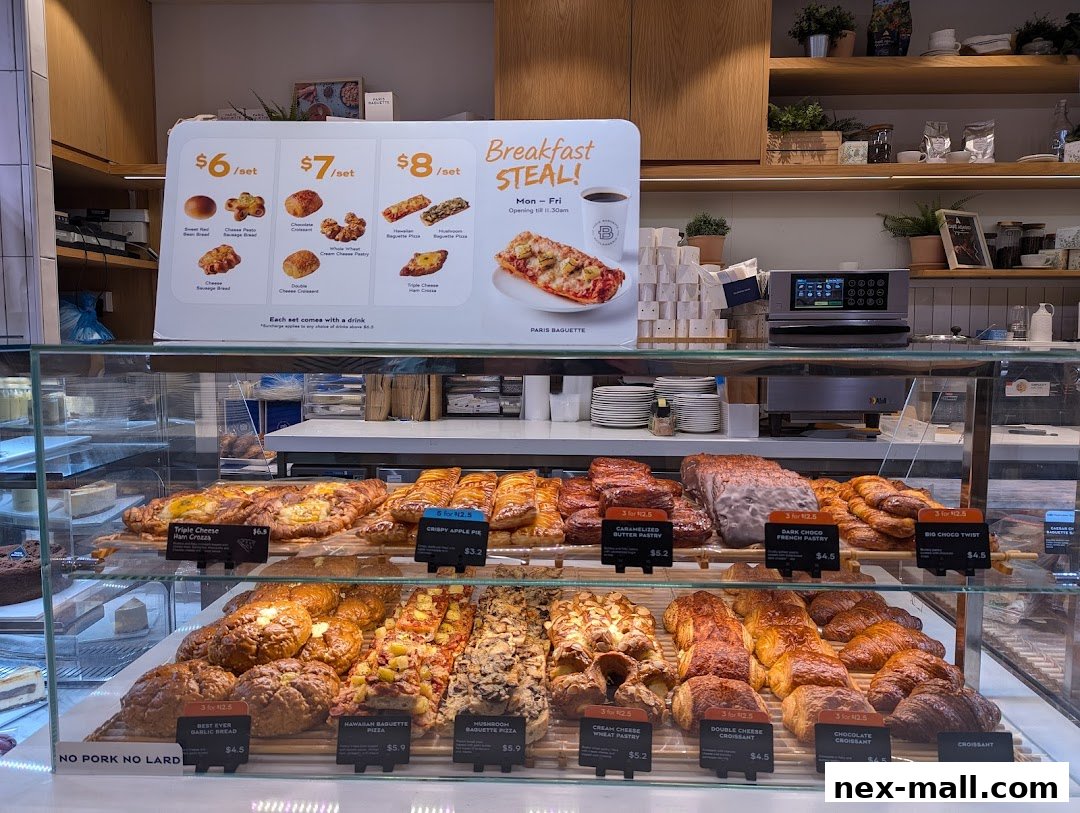 A display case filled with various pastries and baked goods at Paris Baguette NEX.