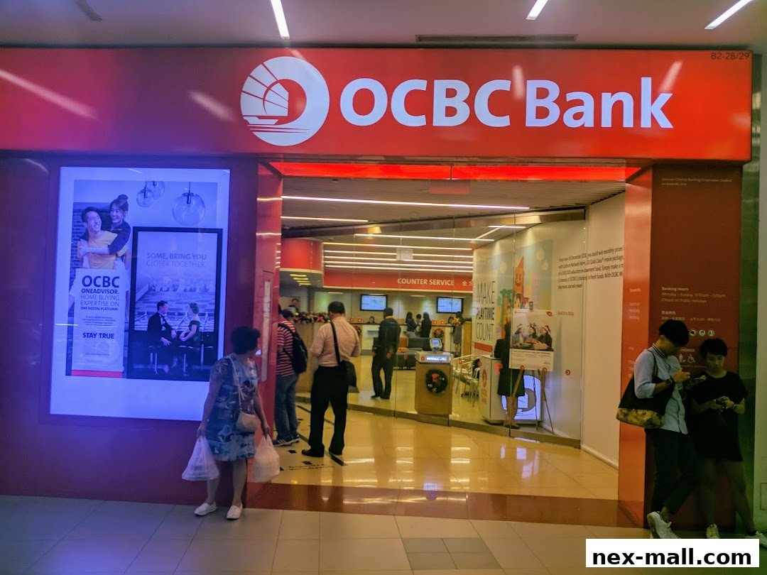 The entrance of OCBC Bank NEX, featuring its prominent red signage and promotional posters.