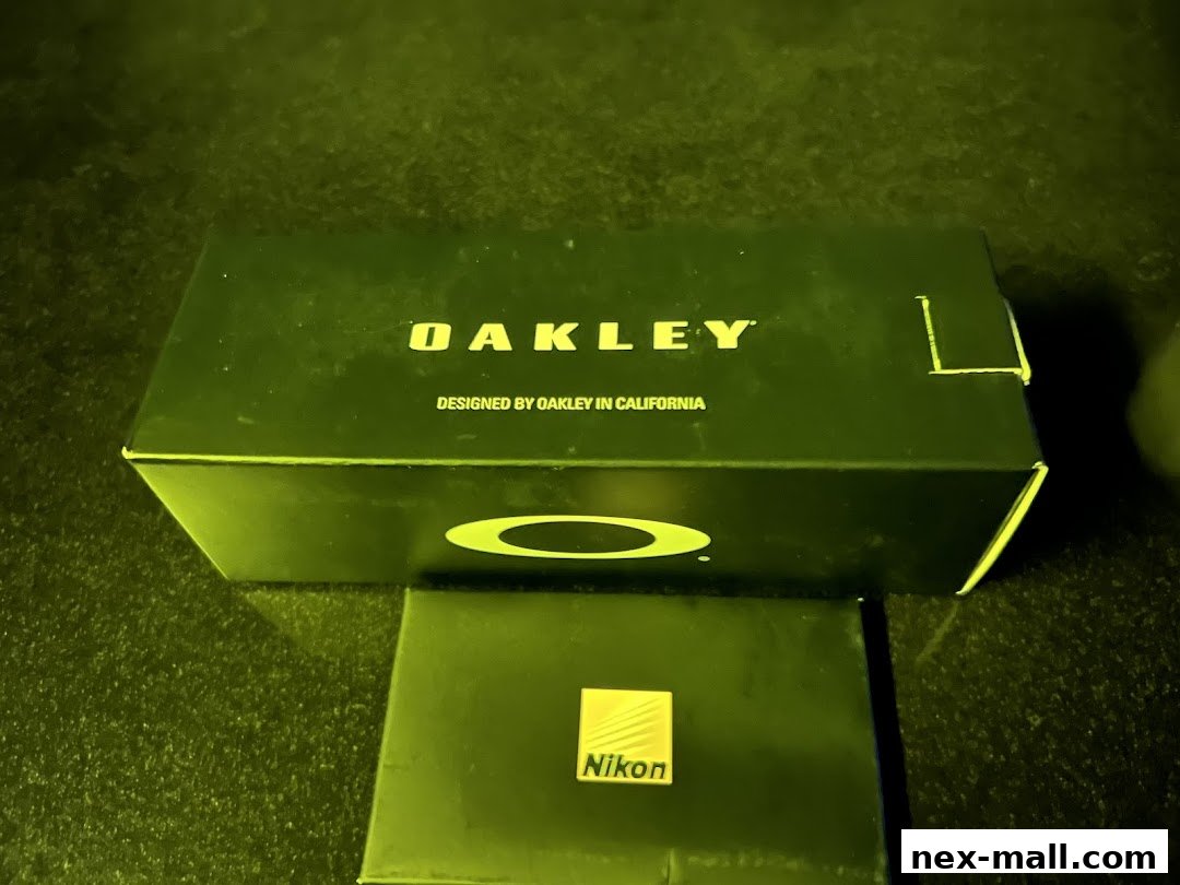 Oakley and Nikon branded boxes are displayed on a dark surface.