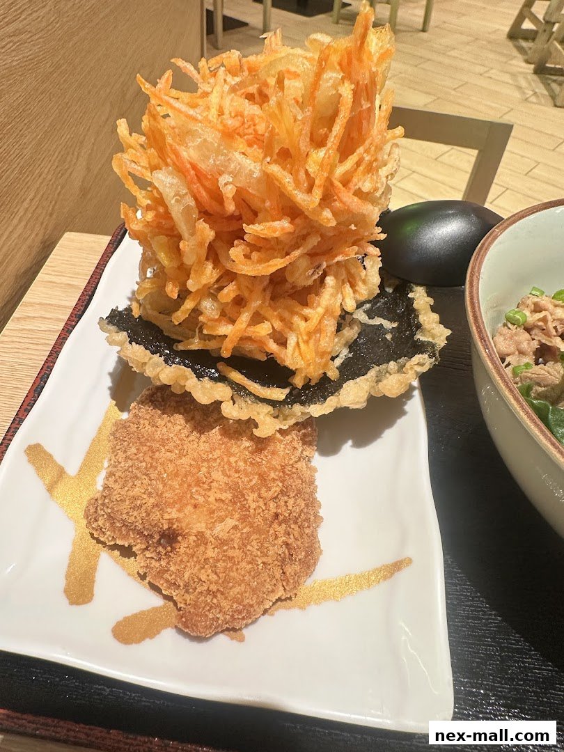 A plate of Japanese fried food, including tempura and a cutlet, served at a restaurant.